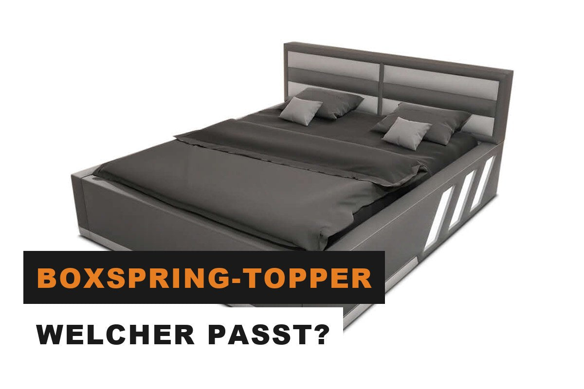 Boxspringbett mit weißem Topper und heller Bettwäsche im Schlafzimmer